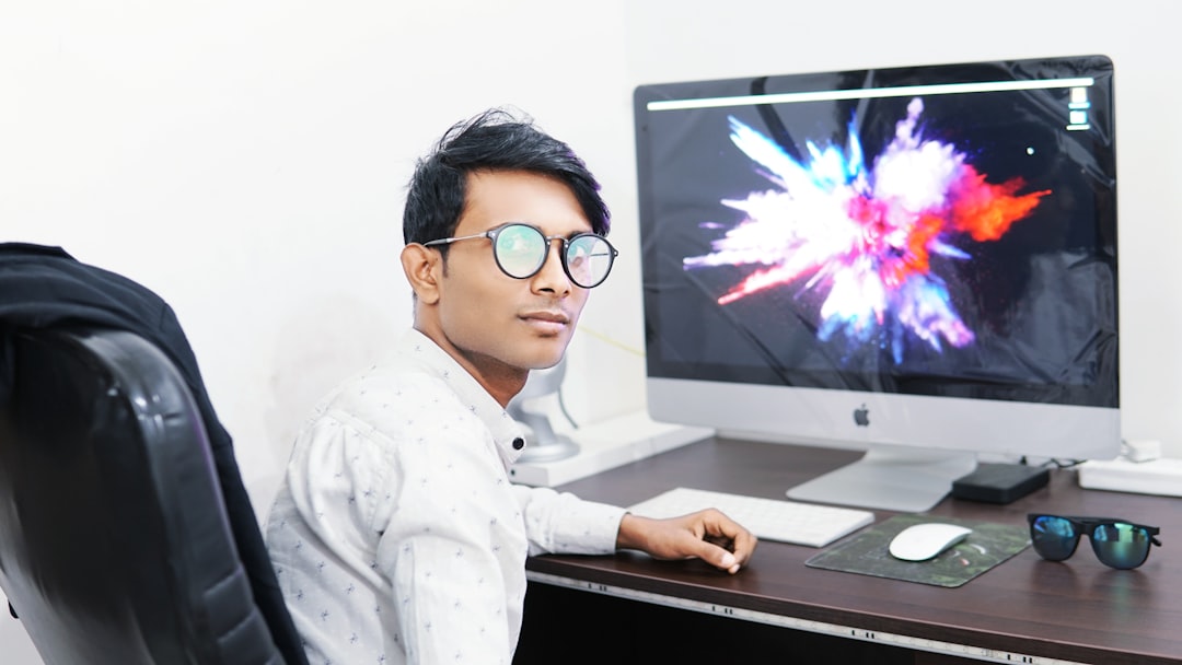 man using iMac representing modern technology workplace