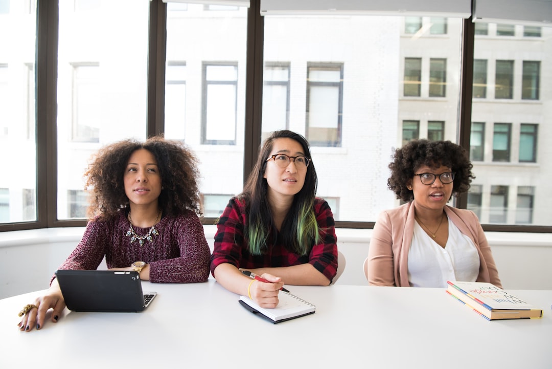 Three women at a table with a laptop in a diverse team