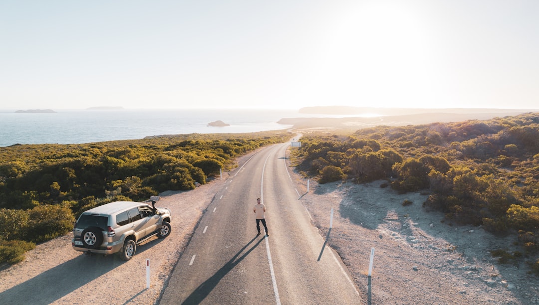 a truck driving down a road next to the ocean autonomous vehicle