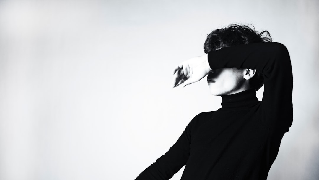 a black and white photo of a woman wearing a black turtle neck top