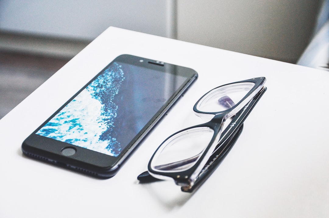 black eyeglasses near iPhone, symbolizing smartphone security