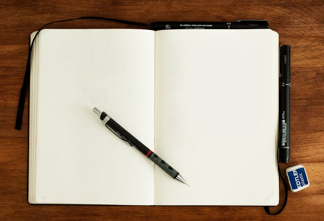 ノートにペンで文字を書いている様子