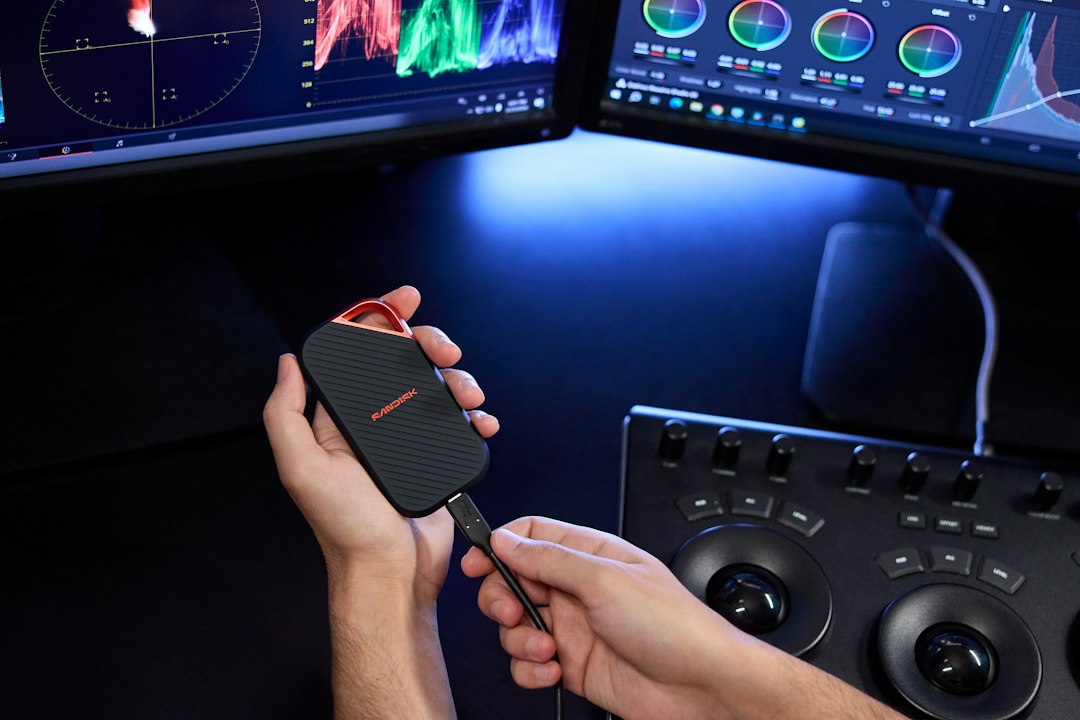 Person connecting a portable ssd to a video editing setup